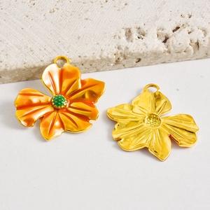 Vista de los colgantes de pétalos de flores DIY con esmalte naranja y acabado dorado