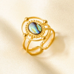 Detailed macro view of 18k gold vintage shell ring on elegant silk fabric background