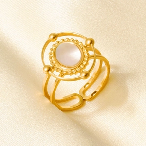 Detail of 18k gold plated ring with a round white shell inlay and textured border