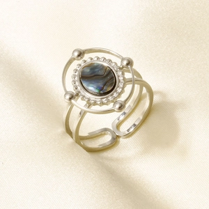 Macro detail of 925 sterling silver ring with colorful abalone shell inlay on silk