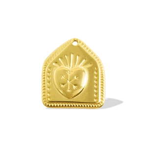 Macro shot of a 18k gold plated heart charm with embossed border and snowflake engraving