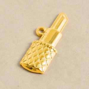 Vue détaillée d'un pendentif rouge à lèvres doré avec une texture matelassée classique