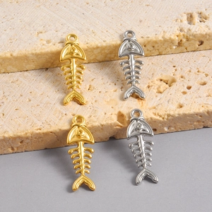 Vue détaillée de pendentifs d'arêtes de poisson dorés et argentés pour création de bijoux