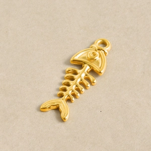 Détail du pendentif en forme d'arête de poisson dorée avec finition métal poli