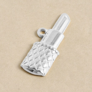 Détail macro du pendentif rouge à lèvres argenté avec motif matelassé et anneau métal