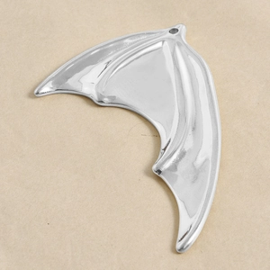Macro shot of silver stainless steel bat wing pendant with polished mirror finish detail