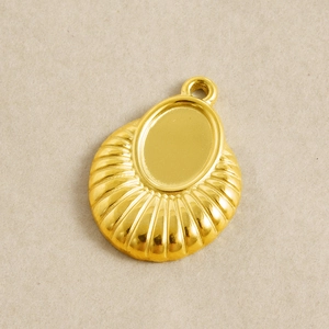 Detail of 18k gold plated fan-shaped pendant with oval base and decorative radial stripes