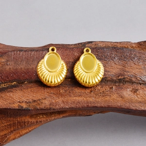 Macro detail of 18k gold fan-shaped pendant base with grooved DIY setting on wood