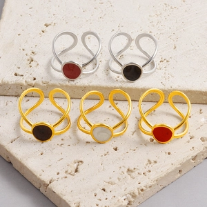 Minimalist geometric open rings with circular enamel inlay on textured stone background