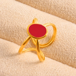 Macro detail of gold geometric ring with red oval drip oil enamel and dual band design