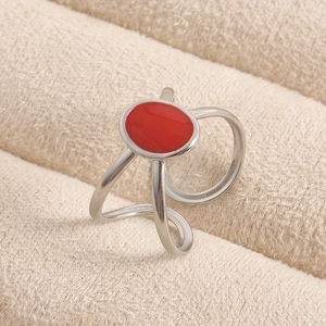 Detailed close-up of a silver irregular open ring with a polished red enamel oval center