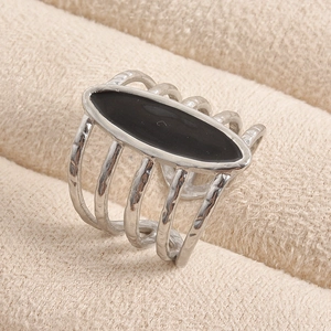 Macro detail of silver layered ring featuring a polished black marquise centerpiece on velvet
