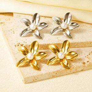 Set orecchini a fiore con perle in oro e argento su elegante sfondo di seta