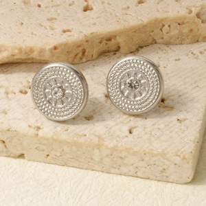 Close-up of vintage round stainless steel stud earrings with shimmering center crystals