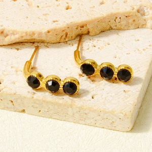Macro view of gold 18k plated tassel stud earrings with black sparkling rhinestones