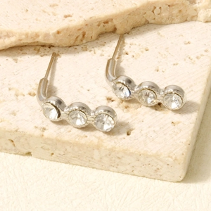 Detailed macro view of silver stud earrings with three curved sparkling rhinestones
