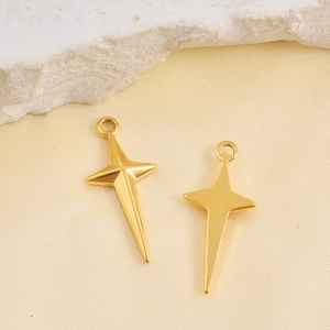 Pair of polished 18k gold plated star pendants on silk background for DIY jewelry