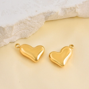 Polished gold heart pendants for DIY jewelry making displayed on elegant silk background