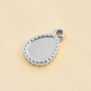 Detailed macro view of a silver stainless steel teardrop pendant tray with beaded edges