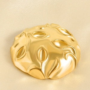 Macro shot of 18k gold leaf embossed texture on polished stainless steel jewelry piece