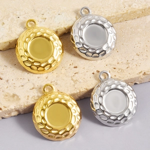 Detail van ronde roestvrijstalen hangers met onregelmatige textuur in goud en zilver