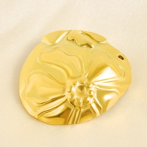 Detailed macro of gold plated floral relief pendant featuring a 925 silver stamp mark