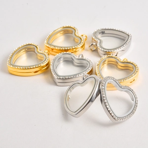 Macro view of gold and silver heart-shaped lockets with crystal borders and clear glass inserts