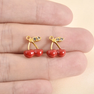 Poliertes 18k Gold Edelstahl Kirsch Anhänger mit rotem Emaille und Kristallen auf dem Finger