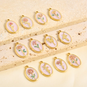 Macro view of oval floral pendants with pink enamel and gold-plated details for DIY jewelry