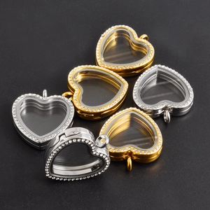 Close-up of heart-shaped floating lockets with rhinestones in gold and silver finishes