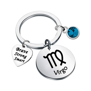 Macro shot of Virgo keychain with engraved heart charm and blue sapphire birthstone pendant