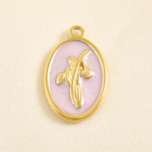 Detail of gold oval pendant with pink enamel finish and raised golden flower relief