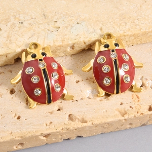 Dettaglio macro di ciondoli a coccinella in smalto rosso con strass e placcatura in oro