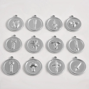 Gedetailleerd raster van 12 roestvrijstalen ronde hangers met retro-reliëf en iconen