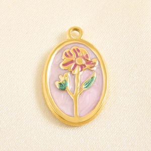 Macro detail of floral enamel oval pendant with pink flower and golden steel frame