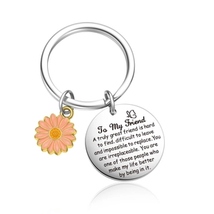 Detail of Friendship Keychain with engraved round charm and pink enamel daisy pendant