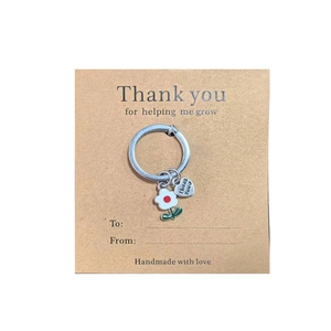 Detail of Thank You For Helping Me Grow keyring with flower and heart pendants on a card