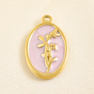 Macro view of a gold oval pendant featuring a pink enamel background and floral relief.