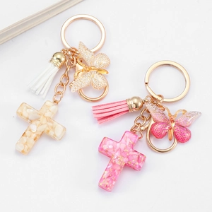 Resin cross keychain with butterfly charm and tassel in white and pink options