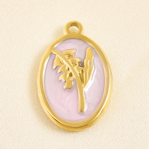 Macro detail of oval gold stainless steel pendant with pink enamel floral relief