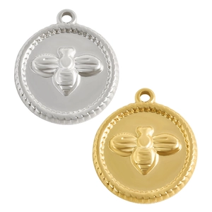 Detailopname van gouden en zilveren muntpendants met bijenreliëf en gedraaide touwranden