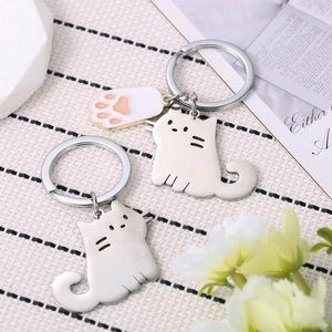 Simpatico portachiavi a gatto in acciaio inox con ciondolo a zampa su sfondo decorato
