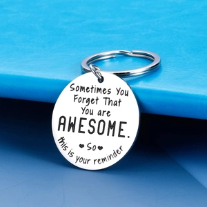 Engraved stainless steel keychain with motivational quote on a blue background