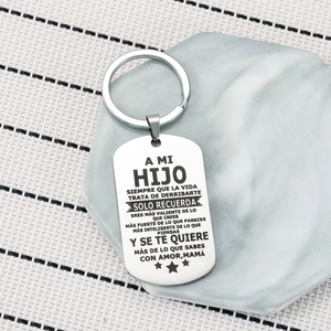 Polished stainless steel military tag keychain with Spanish text on marble base