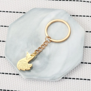 Golden fox keychain set on white marble tray featuring fine engraved details and chain