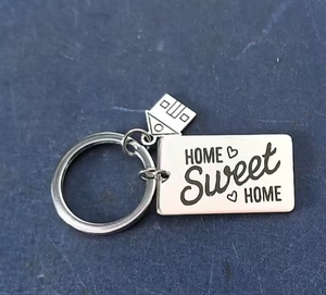 Détail du porte-clés en acier inoxydable avec pendentif maison et gravure Sweet Home