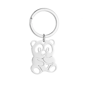 Détail d'un porte-clés panda en acier argenté avec motifs ajourés et petit cœur décoratif