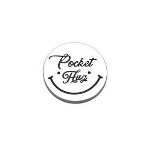Gros plan du jeton Pocket Hug en acier inoxydable avec gravure sourire et cœurs