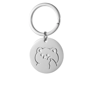 Detailed view of an engraved silver cartoon bear on a polished stainless steel keychain