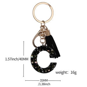 Black resin letter C keychain with colorful star sequins, gold metal clasp and black tassel